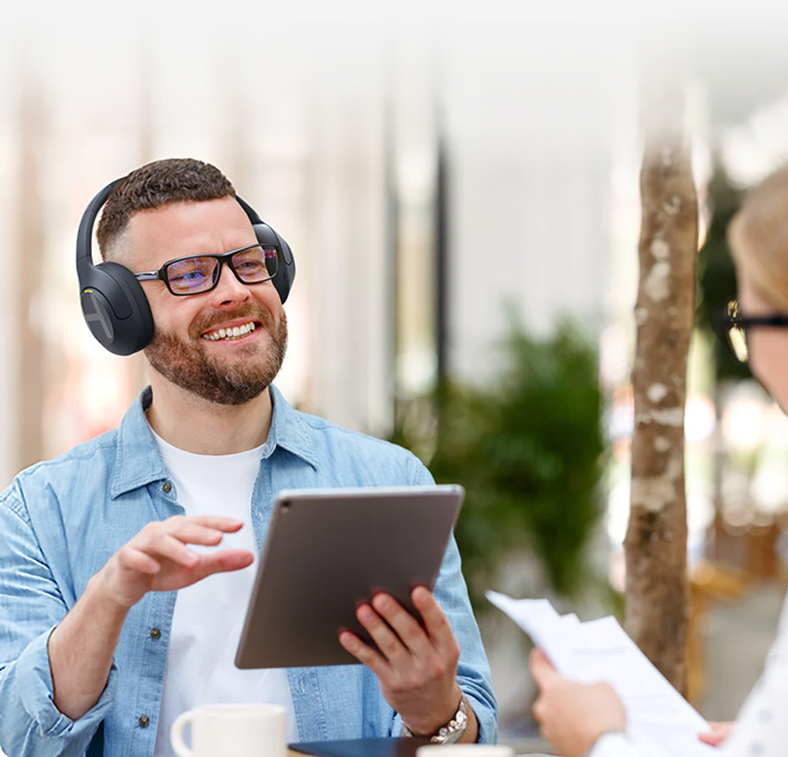 Man holding tablet and listening to Haylou S35 ANC headphones